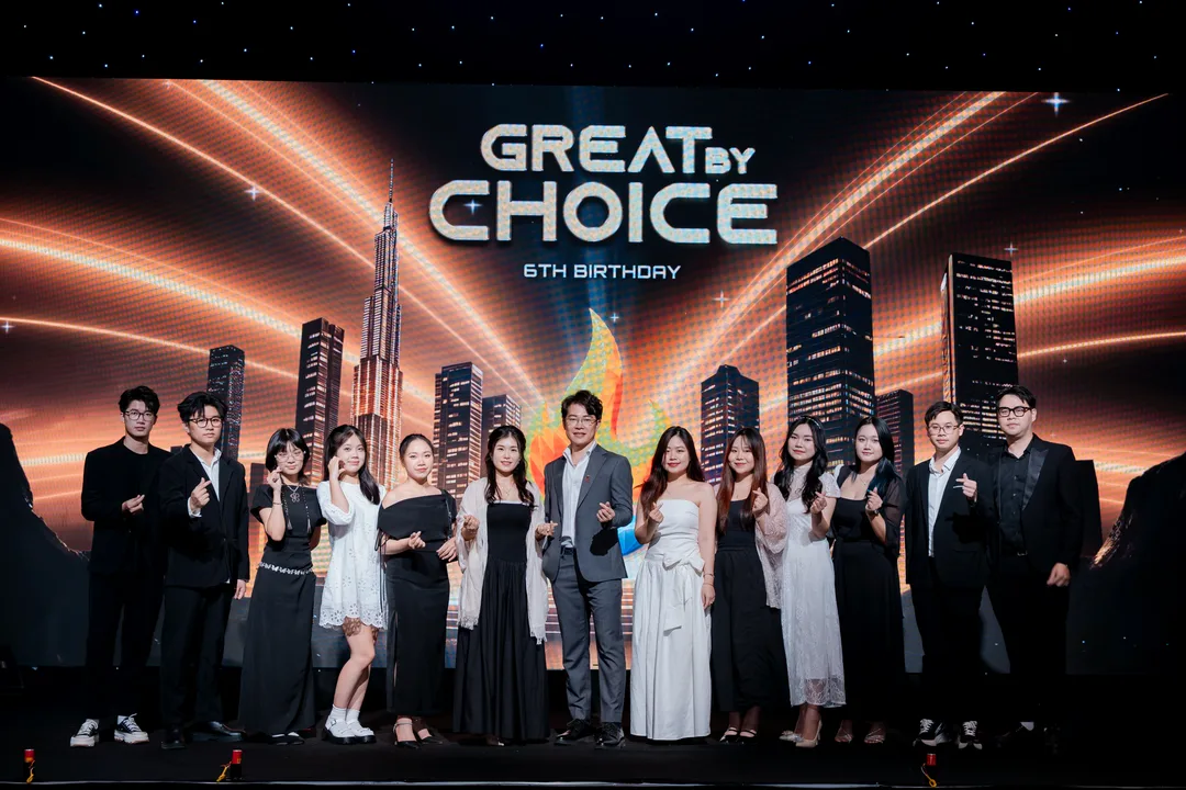 Dmobin team posing on stage at the 6th anniversary 'GREAT BY CHOICE' event, with a city skyline backdrop